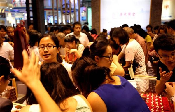 2013年6月23日,广州金交会上,"中国大妈们"在广东黄金展位内疯狂抢购